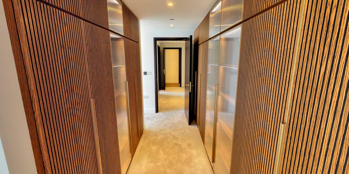 Principal bedroom with curved floor-to-ceiling windows and panoramic views of the Canary Wharf skyline